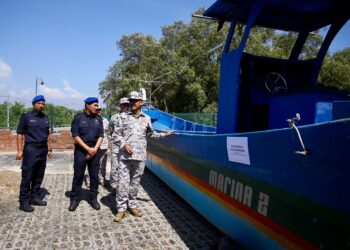 ROMLI Mustafa (kanan) menunjukkan bot yang digunakan untuk menyeludup PATI yang berjaya ditahan dalam operasi bersepadu bersama Pasukan Polis Marin pads sidang akhbar di Bangunan Marina Kuala Kedah di Alor Setar, hari ini. - UTUSAN/ SHAHIR NOORDIN