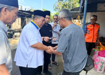 ABU Bakar Hamzah (dua dari kiri) menyerahkan sumbangan kepada mangsa kebakaran di Pulau Ketam, Kuala Perlis, Perlis, semalam– UTUSAN/MOHD. HAFIZ ABD. MUTALIB