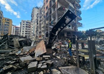 SEORANG lelaki memeriksa sebuah bangunan yang musnah akibat serangan Israel di selatan pinggir Beirut semalam. - AFP