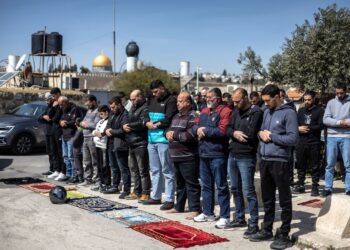 PENDUDUK Palestin menunaikan solat Jumaat di kawasan jalan jauh dari kompleks Masjid Al-Aqsa, Baitulmuqaddis Timur.- AFP
