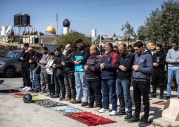 PENDUDUK Palestin menunaikan solat Jumaat di kawasan jalan jauh dari kompleks Masjid Al-Aqsa, Baitulmuqaddis Timur.- AFP