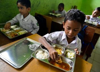 PELAJAR menikmati makanan yang disediakan di bawah program makanan percuma kerajaan Indonesia di sebuah sekolah rendah di Darul Kamal, Aceh.- AFP