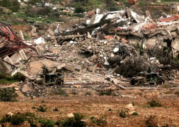 KENDERAAN tentera Israel melintasi bangunan yang musnah di selatan Lubnan, kelmarin. - AFP