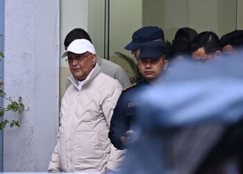 BEKAS Perdana Menteri Nepal, KP Sharma Oli (kiri) diiring anggota polis ketika dibawah ke hospital susulan penangkapannya di Kathmandu semalam.- AFP