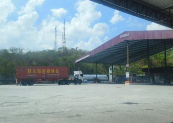 KENDERAAN perdagangan dari Thailand membuat pengisian bahan bakar di stesen minyak tanpa subsidi di Padang Besar, Perlis semalam. -UTUSAN/ASYRAF MUHAMMAD