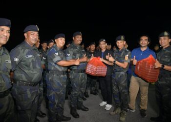 MUHAMAD Azuan Mohamad Nasir (empat dari kanan) menyerahkan pek makanan sahur kepada anggota keselamatan bersempena program Jom Singgah Sahur anjuran Unimap dan PWP di Padang Besar, Perlis semalam.-UTUSAN/IZLIZAN OTHMAN