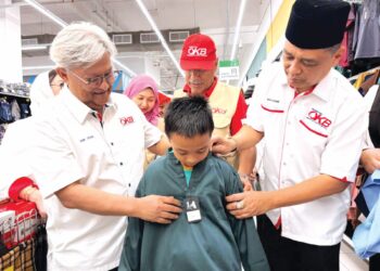 NIK Izani Nik Ibrahim (kiri) memakaikan baju Melayu kepada seorang penerima sumbangan Persatuan Orang Kota Bharu (POKB) dan Persatuan Pengimpot dan Peniaga Kenderaan Melayu Malaysia (PEKEMA) di Kota Bharu semalam. – UTUSAN/ROSLIZA MOHAMED