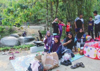 NURSYAHIRA Iffah Ab Aziz (duduk, kiri) berkelah bersama keluarganya di Jeram Rekreasi Sungai Talan di Kampung Bintongan, Rembau. – UTUSAN/NOR SHAFIQAH MOHD GHAZALI