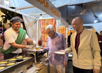 Dr. Abdul Aziz Sheikh Ab. Kadir mencuba juadah (tengah) meninjau hidangan yang disajikan pada Bufet Ramadan Senja Seri Warisan di Klana Beach Resort Port Dickson. -UTUSAN / NOR SHAFIQAH MOHD GHAZALI