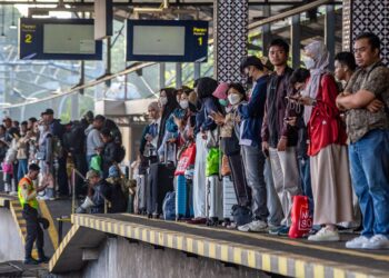 Orang ramai menunggu kereta api ketika mereka dalam perjalanan pulang ke kampung di Stesen Kereta Api Lempuyangan, Yogyakarta kelmarin. - AFP