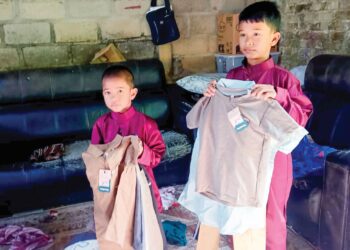 MOHD. Adam Mat Noh (kiri) dan Mohd. Razak menunjukkan pakaian raya sumbangan kerajaan negeri di Felda Kota Gelanggi Empat di Jerantut. Pahang. – UTUSAN/HARIS FADILAH AHMAD