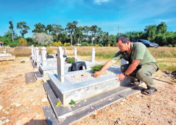 AZIZ Jaafar Yusof menziarah kubur anak-anak dan menantunya di Kampung Selat, Bota Kanan dekat Parit, Perak. – UTUSAN/AIN SAFRE BIDIN