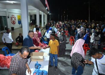 ROZABIL Abd. Rahman (tengah) menyerahkan daging tempatan yang dijual pada harga RM15 sekilogram bersempena program Jualan Rahmah UMNO Arau (Juara) di pekarangan pejabat UMNO Bahagian Arau, 
Perlis semalam. – UTUSAN/IZLIZAN OTHMAN