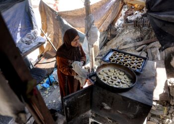 Seorang wanita menyediakan biskut tradisional ‘kaak’ sebagai hidangan menyambut Aidifitri di Semenanjung Gaza, semalam. – AFP