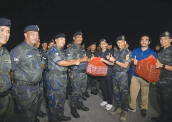MUHAMAD Azuan Mohamad Nasir (empat dari kanan) menyerahkan pek makanan sahur kepada anggota keselamatan bersempena program Jom Singgah Sahur anjuran Unimap dan PWP di Padang Besar, Perlis semalam. – UTUSAN/IZLIZAN OTHMAN