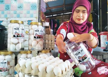 ZAUYAH Derahman menunjukan cara-cara memproses telur masin yang diusahakannya di Kampung Ana, Tumpat, Kelantan.
– UTUSAN/ROHANA ISMAIL