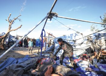 Kanak-kanak Palestin mencari jika ada barang-barang yang masih boleh digunakan selepas serangan tentera Zionis di kem penempatan Nuseirat, tengah Gaza, kelmarin. – AFP