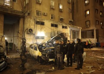 .PASUKAN keselamatan Israel memeriksa kerosakan pada kereta selepas serangan roket di Holon, Israel semalam. - AFP