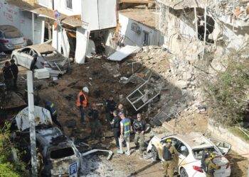 ANGGOTA perkhidmatan kecemasan Israel berkumpul di lokasi serangan misil Iran di Tel Aviv, kelmarin. - AFP