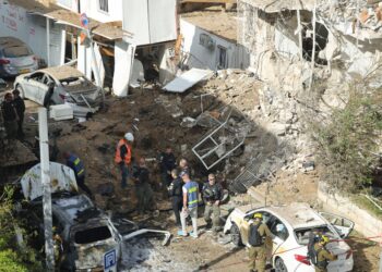 ANGGOTA perkhidmatan kecemasan Israel berkumpul di lokasi serangan misil Iran di Tel Aviv. - AFP