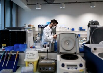 SEORANG saintis mengkaji tentang sampel Covid-19. - Foto AFP