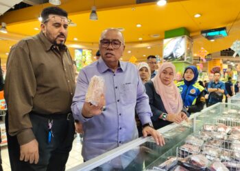 MOHD. Zolkafly Harun (tengah) melihat daging yang dijual di Pasar Raya Besar Mydin Meru Raya ketika mengadakan pemantauan harga barang di premis berkenaan hari ini.