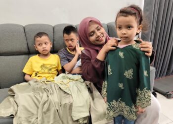 NUR Aini Samiun menunjukkan baju raya yang disediakan untuk anaknya  ketika ditemui di Tanjung Rambutan di Ipoh.