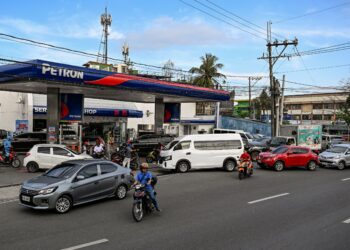 BEBERAPA buah kenderaan beratur di sebuah stesen petrol di tengah-tengah kenaikan harga di Manila awal bulan ini. - AFP