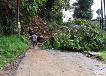 TANAH dan serpihan akibat tanah runtuh yang dicetuskan gempa bumi menghalang sebatang jalan di Cugenang, Cianjur, November 2022. - AFP