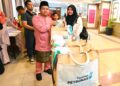 NURLY Hunida Abu Bakar (kanan) yang juga orang kurang upaya (OKU) menerima sumbangan Yayasan Petronas pada majlis iftar sempena Program Memacu Kehidupan: Hari Raya Aidilfitri 2026 di Kuantan, Pahang. - FOTO/SHAIKH AHMAD RAZIF
