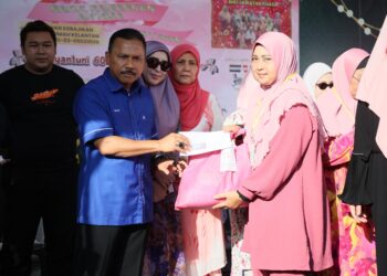 MOHD. Yusoff Mamat (kiri) menyampaikan sumbangan kepada golongan asnaf di Lembah Sireh, Kota Bharu, Kelantan hari ini-UTUSAN/KAMARUL BISMI KAMARUZAMAN.