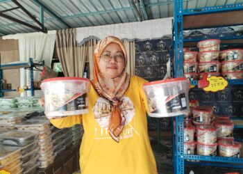 NURUL Kamila Awang menunjukkan biskut raya yang dijual di gerainya di Bandar Permaisuri, Setiu, Terengganu. - UTUSAN / WAN ZURATIKAH IFFAH WAN ZULKIFLI