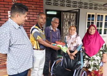 M. KULASEGARAN melawat mangsa ribut, Jumaini Wari (dua dari kanan) di Kampung Tasek, Ipoh hari ini.