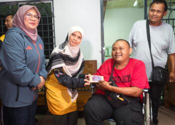 MARHAMAH Rosli  menyampaikan sumbangan kepada penerima sempena program Singgah Sahur Bulan Wakaf Malaysia di Pantai Kundor, Melaka, semalam. – UTUSAN/AMRAN ALI