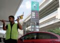SEORANG pekerja stesen minyak di Kuala Lumpur membantu pelanggan mengisi petrol RON95 ke dalam tangki kereta. – UTUSAN/ISKANDAR ISHAK