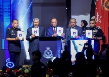ANWAR Ibrahim dan Timbalan Perdana Menteri, Datuk Seri Dr. Ahmad Zahid Hamidi (dua kiri) menunjukkan Buku Mesra PDRM Modul Kesedaran Jenayah Kanak-Kanak dan Remaja pada Sambutan Peringatan Hari Polis ke-219 di Pusat Latihan Polis, Kuala Lumpur semalam.-UTUSAN/FARIZ RUSADIO