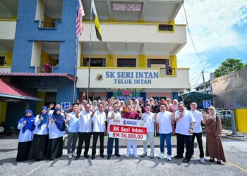 NGA Kor Ming (tengah) menyerahkan peruntukan RM50,000 kepada SK Seri Intan di Teluk Intan hari ini.