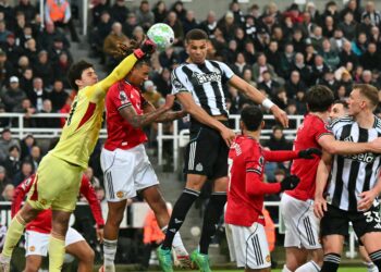 Penjaga gol Manchester United, Senne Lammens (kiri) menumbuk bola keluar dari kawasan bahaya dalam aksi Liga Perdana Inggeris menentang Newcastle United di St James' Park, semalam. - AFP