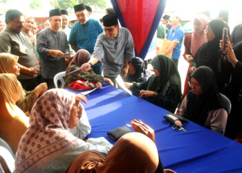 Mohammed Taufiq Johari menyampaikan duit raya kepada golongan asnaf dan fakir miskin selepas merasmikan Program Rakan Masjid X Rakan Muda Ramadan Peringkat Negeri Melaka di Masjid Al-Abrar, Semabok hari ini. UTUSAN/AMRAN MULUP