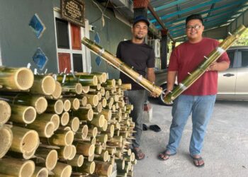 ZURIN Fazril Zulkifli (kiri) dan Junaidi Azrin Ahmad (kanan) menunjukkan pelita buluh yang dihasilkan di Jalan Tasik Melati, Beseri, Perlis semalam.- UTUSAN/ASYRAF MUHAMMAD