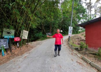 MUKHTARUDDIN Abdul Wahid menunjukkan arah ke bukit iaitu trek larian Gopeng Ultra Trail yang dilalui Acap sebelum dilaporkan hilang pada tahun 2019. - UTUSAN/AIN SAFRE BIDIN