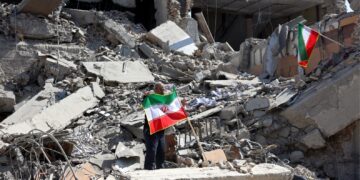 SEORANG lelaki mengibarkan bendera Iran di sebalik runtuhan bangunan kesan serangan udara oleh Amerika Syarikat (AS) dan sekutunya ke atas Teheran, kelmarin. Serangan terhadap Iran sudah memasuki hari keenam dengan kira-kira 1,000 orang dilaporkan terbunuh. – AFP