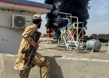 ANGGOTA keselamatan Taliban melihat kebakaran besar di depot minyak untuk sebuah syarikat penerbangan komersial, berhampiran lapangan terbang Kandahar di daerah Daman, wilayah Kandahar.- AFP