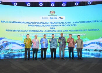 AMIR Hamzah Azizan (tengah) dan Tan Sri Shamsul Azri Abu Bakar (tiga dari kiri) bersama dif-dif kehormat semasa majlis penyempurnaan pembinaan landasan jajaran utama ECRL dari Kota Bharu ke Gombak sepanjang 519 kilometer.