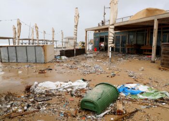 SEORANG lelaki membersihkan lumpur selepas berlaku ribut di restorannya di bandar pesisir Netanya, utara Tel Aviv, Israel pada 25 Disember 2019. - AFP