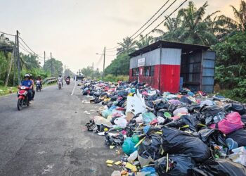 KEADAAN sampah yang dibuang di laluan utama Kampung Bahagia di Teluk Intan. - UTUSAN/AIN SAFRE BIDIN