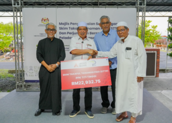 MENTERI Pertanian dan Keterjaminan Makanan, Datuk Seri Mohamad Sabu (dua kiri) menyampaikan Skim Takaful Penanaman Padi kepada penerima di Kedah, baru-baru ini.