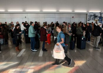 PENUMPANG terpaksa menunggu dalam barisan panjang  di Lapangan Terbang LaGuardia, New York. - AFP