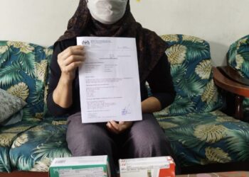 NORHAFAIZA Taib menunjukkan dokumen perubatannya
di Kampung Sungai Karang Pantai 
di Kuantan, Pahang.