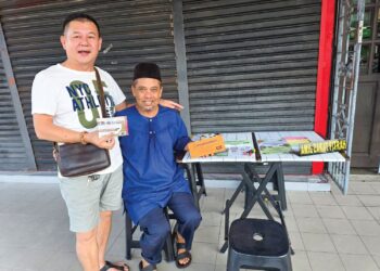 HELEN Tan Chua menunjukkan resit bayaran selepas menyerahkan derma kepada Mat Nazer Che Rose di Teluk Intan semalam. – UTUSAN/AIN SAFRE BIDIN